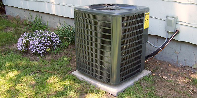 AC condensing unit with label listing specs such as tonnage.