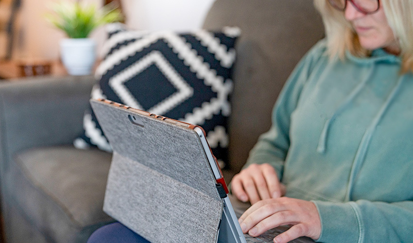 Woman using a tablet while sitting on couch