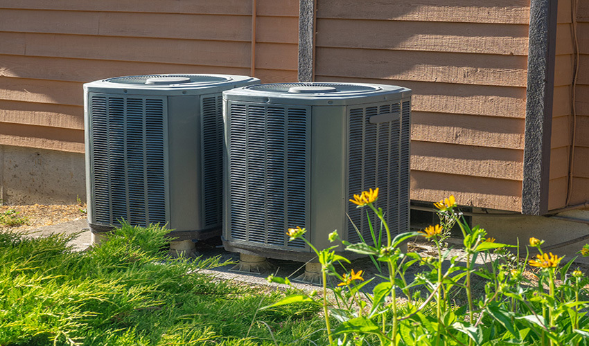 Two air conditioner condensing units outside of home